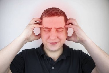 A man holds his head with his hands. Sensation of headache, migraine and dizziness. Headaches from stress or overwork clipart