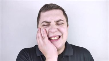 Bir adam yanağına yapışır ve dişinde acı hisseder. Diş problemleri, bakteriler, diş çürükleri, akı kavramı. Metin için beyaz arkaplan ve yer.