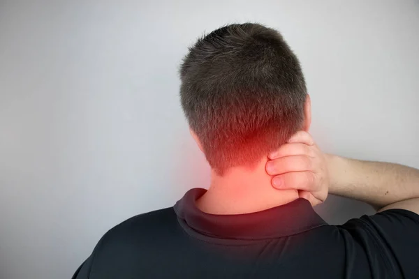 A man suffers from pain in the neck, massages the cervical spine with his hand. Osteochondrosis, hernia, or nerve injury due to sedentary work or physical stress — Stock Image Man Suffers Pain Neck Massages Cervical Spine His Hand Osteochondrosis Royalty Free Stock Images