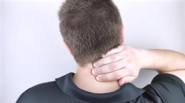 Bir adam boynundaki ağrıdan muzdarip, servikal omurgaya eliyle masaj yapıyor. Osteokondrosis, fıtık, ya da yerleşik iş ya da fiziksel stres kaynaklı sinir hasarı