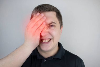 Bir adam gözündeki acıdan muzdariptir. Göz hastalığı, uveit, optik sinir iltihabı, konjonktivit veya göz hasarı olan bir hasta.