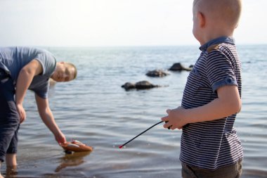 Baba ve oğul radyoda bir gemi fırlatıyorlar. Baba, çocuğa uzaktan kumandada tekneyle nasıl oynanacağını gösteriyor. Kumsalda dinlenmek ve mutlu bir çocukluk geçirmek.