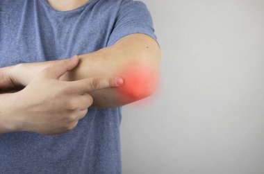 Dirsek ağrısından muzdarip bir adam. Dirsek eklemi zedelenmesi, kemik kırığı ya da burkulma. El yaralanması ve esnek ağrı konsepti