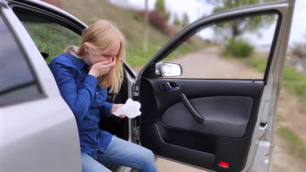 金髪の少女は車を運転できなくなった 嘔吐は嘔吐が乗客室に入らないように彼女に車の外を見ることを強制した 少女は運動失調 乗り物酔い — ストック動画