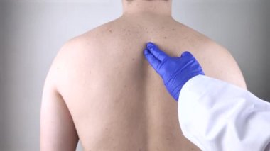 Omurga ağrısı. Doktor randevusundaki bir adam nörolog ve omurgacı ile görüşüyor. Sırt hastalıkları: sinir sıkışması, omurgalar arası fıtık, ya da osteokondrosis.