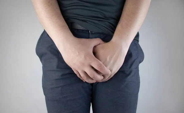 Man front view. Pain in the groin and bladder. The concept of pain in men as a result of prostatitis, inflammation of the bladder or genitourinary system. Frequent urination.
