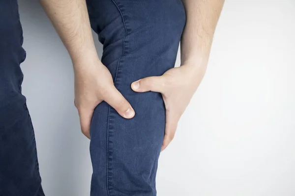 A man suffers from pain in the calves. Stretching the calf muscle, varicose veins, leg cramps, or myositis. Orthopedic doctor examines — Stock Image Man Suffers Pain Calves Stretching Calf Muscle Varicose Veins Leg Royalty Free Stock Photos