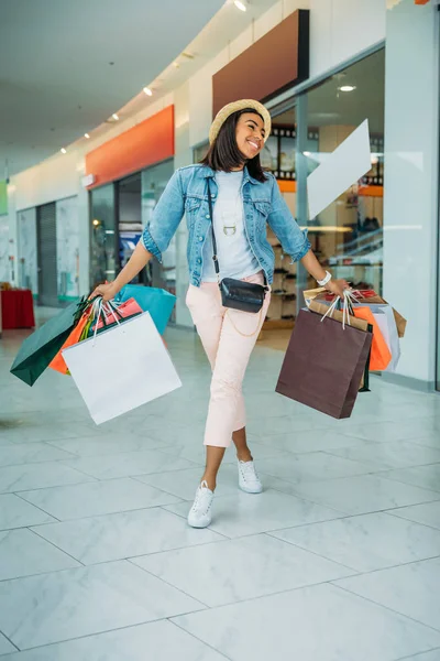 Jeune femme avec des sacs à provisions — Photo de stock