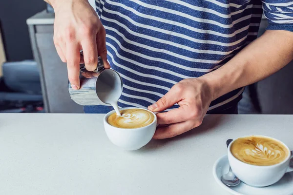 Mann schüttet Milch in Kaffee — Stockfoto