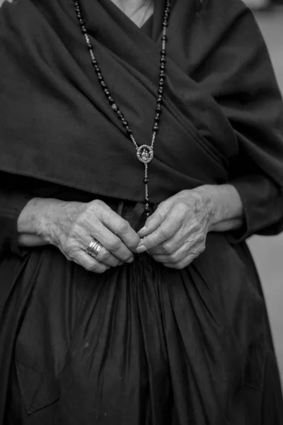 Woman in mourning with a rosary