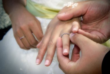 Gelin ve damat bir alyans koyarak eller yukarı kapatın