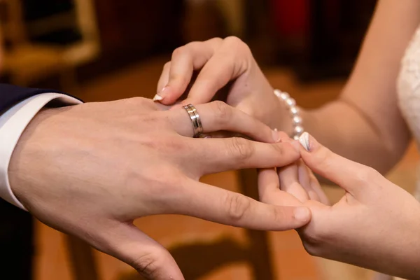 Fermer les mains de mariée et marié mettre sur une alliance — Photo