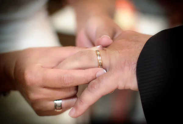 Nära håll händerna på bruden och brudgummen att sätta på en vigselringar — Stockfoto