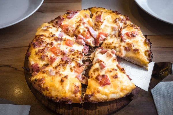 Presunto de pizza quente e queijo com fundo de madeira . Imagens Royalty-Free