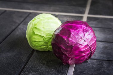 Yeşil ve mor lahana siyah ahşap arka plan üzerinde izole.