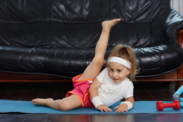 Rubia Niña Pequeña Casa Entrenamiento Una Alfombra Azul —  Fotos de Stock