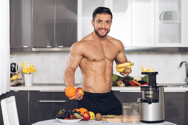 Jovem Homem Apto Com Frutas Cozinha Segurando Banana Laranja Maçã — Fotografia de Stock