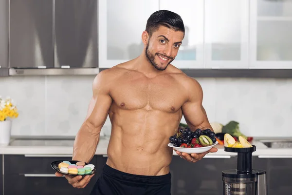 Hombre Joven Forma Cocina Sosteniendo Dos Platos Resistiendo Tentación Comer —  Fotos de Stock