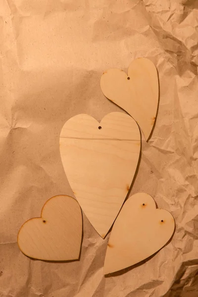 Corações de madeira em papel kraft amassado — Fotografia de Stock