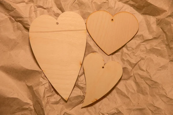 Buruşturulmuş kraft kağıt üzerinde ahşap kalpler — Stok fotoğraf