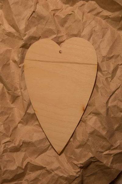 Dřevěné srdce na papír zmačkaný kraft Royalty Free Stock Obrázky