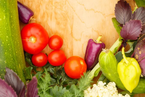 Harvest of fresh vegetables on a wooden background, in garden background. Top view. Garlic, beet, zucchini, kohlrabi, cauliflower, pepper, tomatoes, potatoes, basil, cucumber, dill. — Stock Image Harvest Fresh Vegetables Wooden Background Garden Background Top View Garlic Royalty Free Stock Images