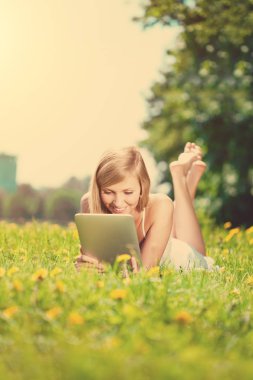 Tabletli, açık havada gülümseyen güzel bir kadının portresi. 