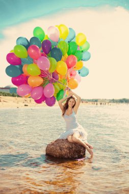 çok renkli gökkuşağı balonları ellerinde gökyüzü güzel genç şık kadın. doğa üzerinde olumlu bir kız. gülümseyen kadın outdoors tadını çıkarıyor.