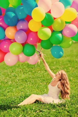 mutlu yıllar kadın ona ellerine gökkuşağı renginde hava balonu gökyüzüne karşı. güneşli ve pozitif enerji doğa. genç güzel kız parkta çim.