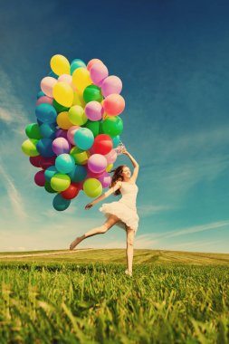 mutlu yıllar kadın ona ellerine gökkuşağı renginde hava balonu gökyüzüne karşı. güneşli ve pozitif enerji doğa. genç güzel kız parkta çim.