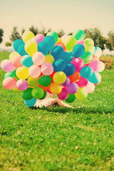 生日快乐对天空的彩虹色气球在她手中的女人 大自然的阳光明媚和积极的能量 年轻漂亮的女孩 在公园的草地上 — 图库照片