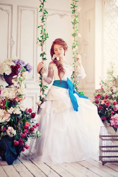 Mooie bruid in een luxe interieur met bloemen — Stockfoto