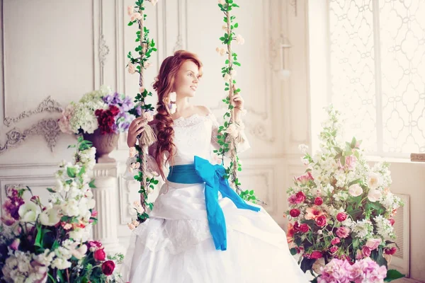 美丽的新娘在一个豪华的室内用鲜花 免版税图库图片