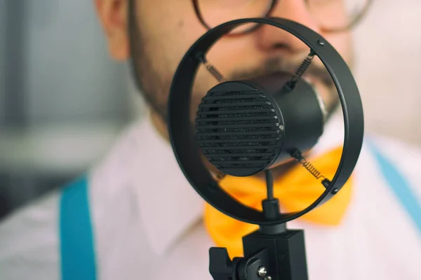 Zanger tijdens het zingen van een sessie op een vintage zwarte microfoon Rechtenvrije Stockafbeeldingen