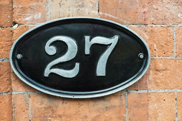 Nummer 27 vintage metalen plaat op een bakstenen muur — Stockfoto