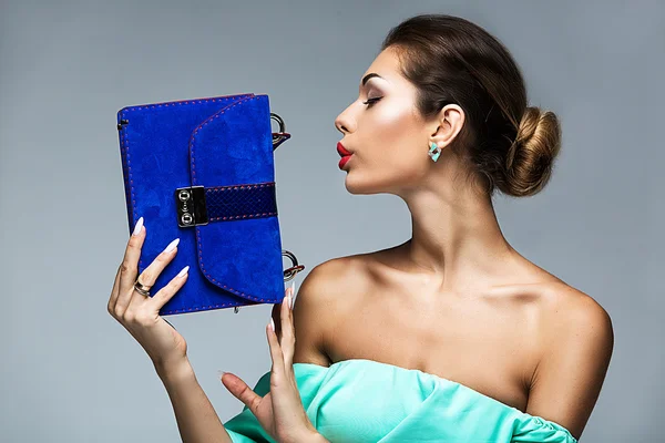 Närbild porträtt av en flicka som håller en blå väska i händerna — Stockfoto