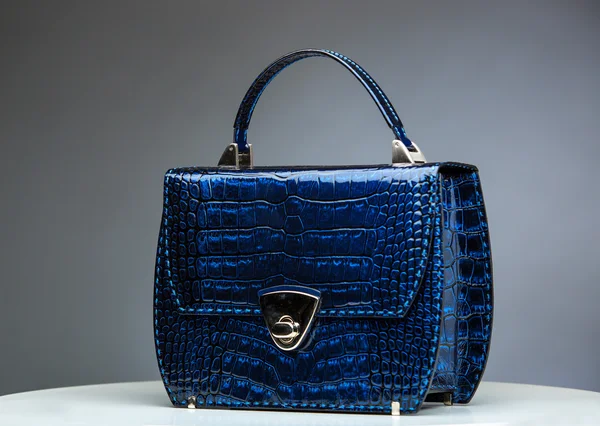 Mörkt blå kvinnliga läderväska med reptil hud Detaljer isolerade på grå. Stockbild