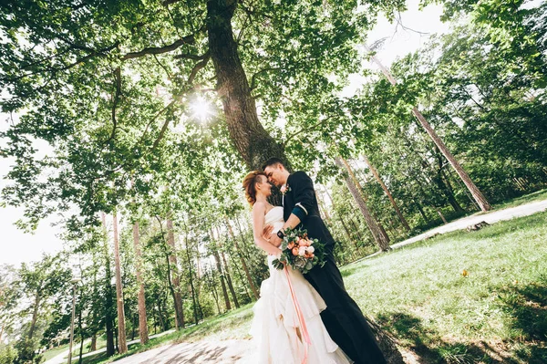 Getrouwd paar knuffelen elkaar in de buurt van boom — Stockfoto