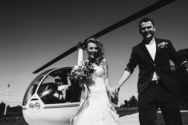Bruid en bruidegom permanent in de buurt van de helikopter — Stockfoto