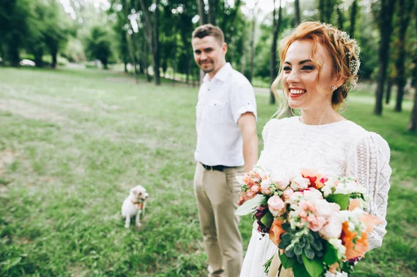 Bruid en bruidegom op wandelen met hond — Stockfoto