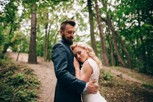 Bruden och brudgummen står i skogen — Stockfoto