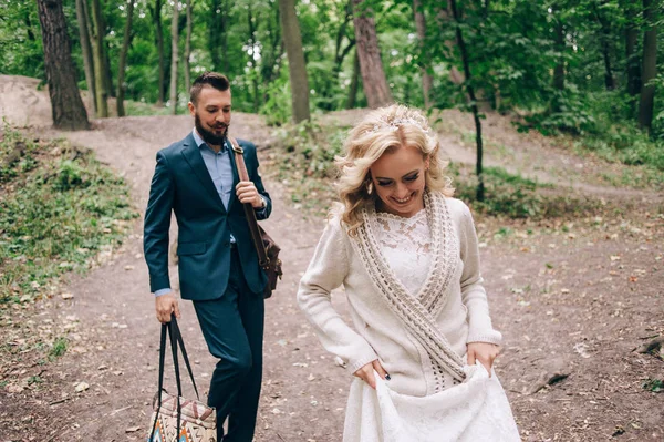 Bruid en bruidegom lopen in bos — Stockfoto