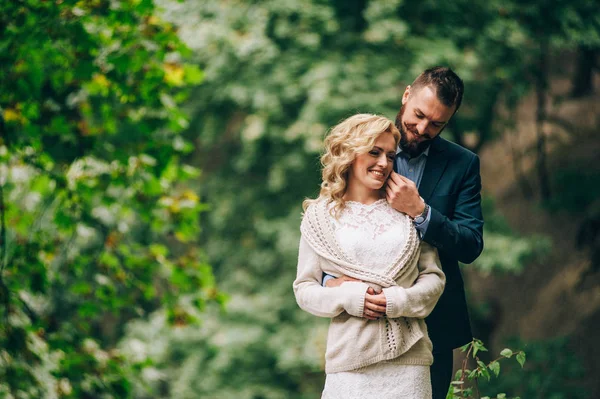 Bruid en bruidegom staan in bos — Stockfoto