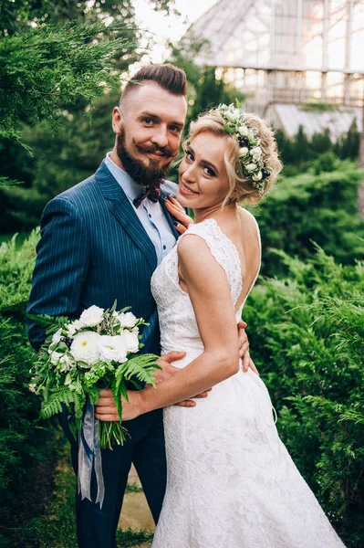 Novia y novio en el camino en el jardín de la ciudad — Foto de Stock