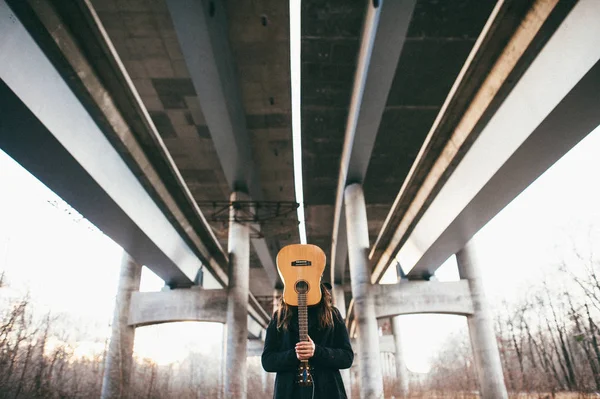 Hombre con guitarra bajo puente — Foto de Stock