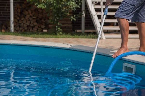 Homem limpando a piscina com aspirador — Fotografia de Stock