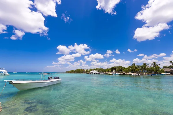 Białe łodzi w pobliżu skalistego brzegu w Bayahibe, La Altagracia, Dominikana. Kopiować miejsca na tekst. — Zdjęcie stockowe
