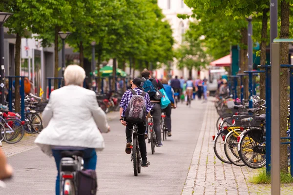OLDENBURG, TYSKLAND - JUNI 10, 2017: En gruppe cyklister rider rundt i den gamle bydel. Kopier plads til tekst . - Stock-foto