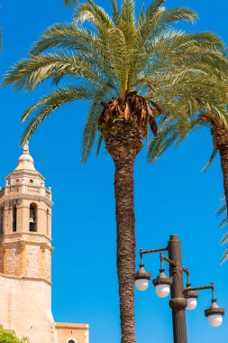 Sant Bartomeu kilise ve Santa Tecla Catalunya Sitges, Barcelona, İspanya kuleye bakış. Metin için yer kopyalayın. Üzerinde mavi arka plan izole. Dikey.       