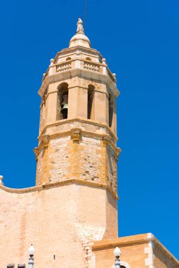 Sant Bartomeu kilise ve Santa Tecla Catalunya Sitges, Barcelona, İspanya kuleye bakış. Metin için yer kopyalayın. Üzerinde mavi arka plan izole. Dikey.       